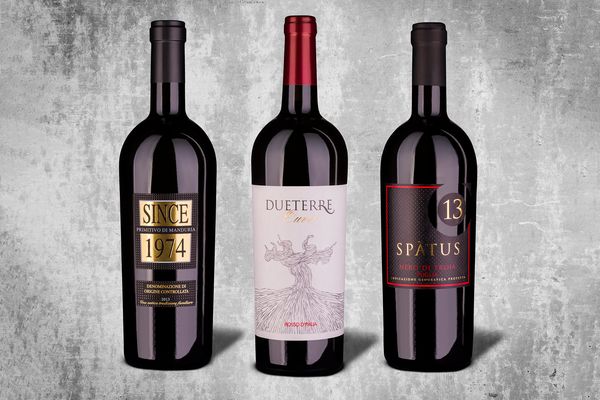 Werbefotografie von Weinflaschen - 3 Flaschen italienischer Rotwein auf Hintergrund mit Betonstruktur und Schatten